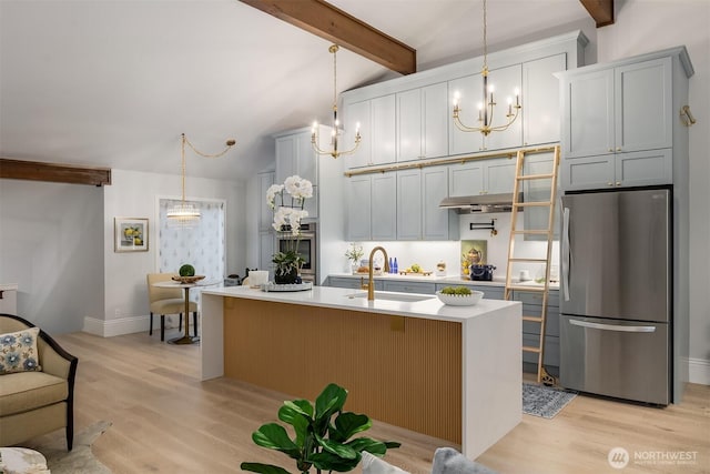 1518 NE 140th St Unit C6, Seattle, WA 98125 - kitchen with freestanding refrigerator, a chandelier, light countertops, and light wood-style floors