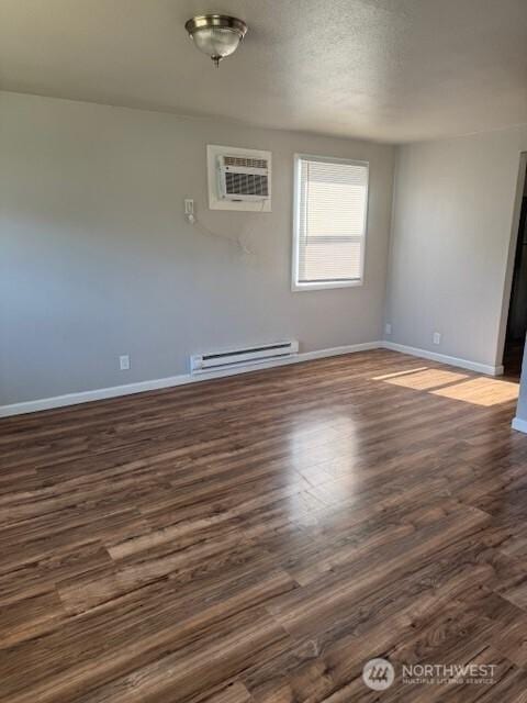 330 SW 5th Ave Unit 336, Ephrata, WA 98823 - unfurnished room featuring a baseboard radiator, a wall mounted AC, and dark wood finished floors