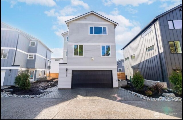 6732 21st Ave SW, Seattle, WA 98106 - view of front facade with an attached garage, driveway, and board and batten siding