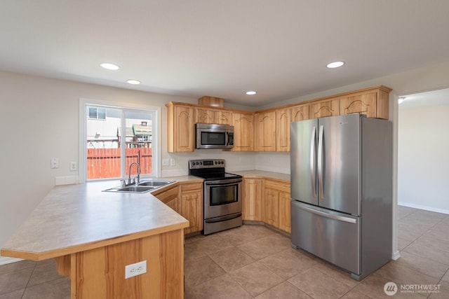 510 Trout Ave NE, Moses Lake, WA 98837 - kitchen with appliances with stainless steel finishes, a peninsula, light countertops, light brown cabinetry, and recessed lighting