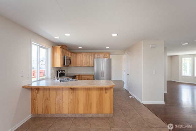 510 Trout Ave NE, Moses Lake, WA 98837 - kitchen featuring appliances with stainless steel finishes, light countertops, a peninsula, recessed lighting, and tile patterned floors