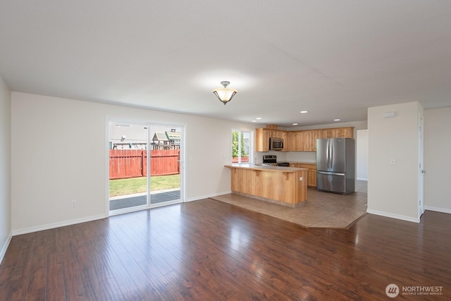 510 Trout Ave NE, Moses Lake, WA 98837 - kitchen featuring appliances with stainless steel finishes, a peninsula, open floor plan, light countertops, and recessed lighting