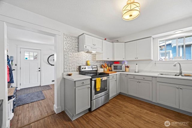 2413 Queen St, Bellingham, WA 98229 - kitchen with electric stove, gray cabinets, under cabinet range hood, light countertops, and dark wood-style flooring