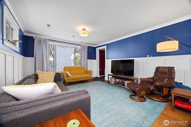 2413 Queen St, Bellingham, WA 98229 - living area featuring a wainscoted wall, ornamental molding, a decorative wall, and wood finished floors