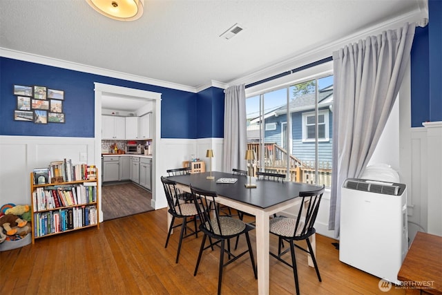 2413 Queen St, Bellingham, WA 98229 - dining area with wainscoting, a decorative wall, ornamental molding, hardwood / wood-style flooring, and a textured ceiling