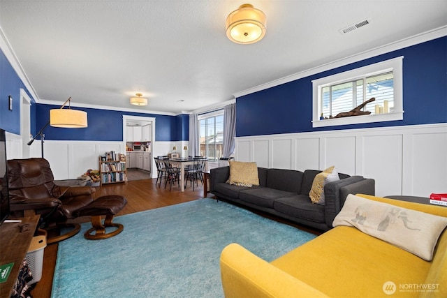 2413 Queen St, Bellingham, WA 98229 - living area featuring a wainscoted wall, ornamental molding, a decorative wall, and wood finished floors