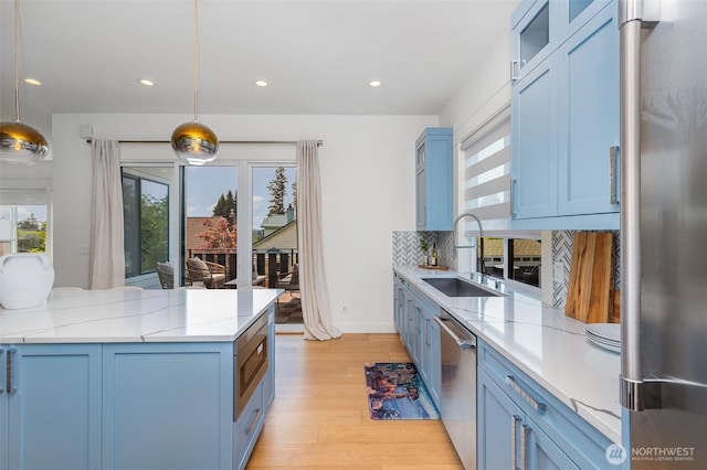 6209 32nd Ave NE, Seattle, WA 98115 - kitchen with appliances with stainless steel finishes, blue cabinetry, light wood-type flooring, tasteful backsplash, and recessed lighting