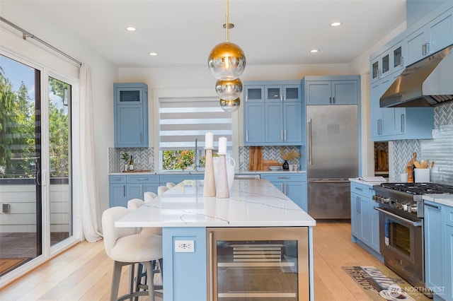 6209 32nd Ave NE, Seattle, WA 98115 - kitchen with wine cooler, premium appliances, under cabinet range hood, light wood-style floors, and blue cabinets