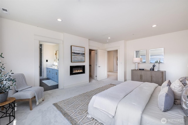 6209 32nd Ave NE, Seattle, WA 98115 - bedroom with light carpet, a glass covered fireplace, recessed lighting, and connected bathroom