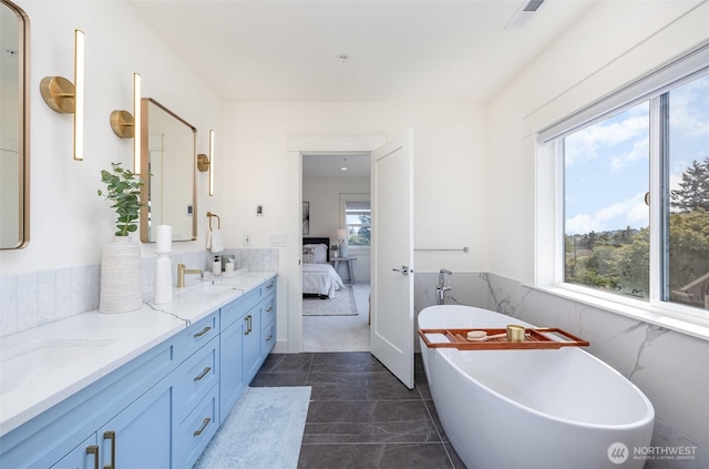 6209 32nd Ave NE, Seattle, WA 98115 - bathroom featuring ensuite bathroom, double vanity, a freestanding tub, marble look tile flooring, and a wainscoted wall
