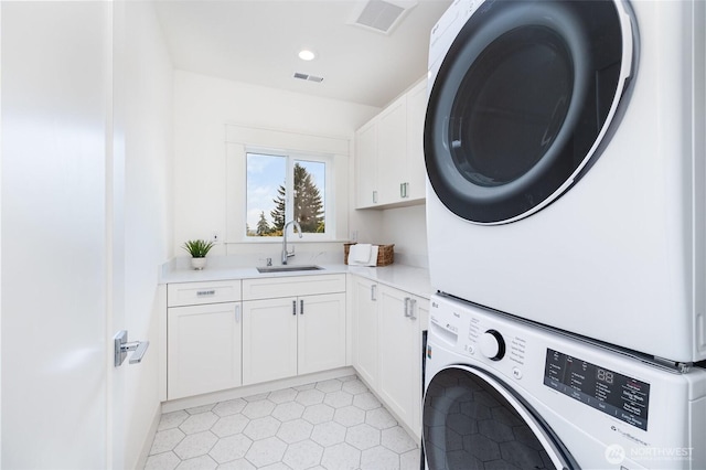 6209 32nd Ave NE, Seattle, WA 98115 - laundry area featuring stacked washer / dryer, cabinet space, light tile patterned flooring, and recessed lighting