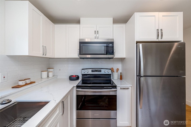 6209 32nd Ave NE, Seattle, WA 98115 - kitchen featuring appliances with stainless steel finishes, white cabinetry, decorative backsplash, and light stone counters