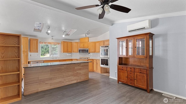 41427 Mountain View Pl E, Gold Bar, WA 98251 - kitchen featuring an AC wall unit, appliances with stainless steel finishes, decorative backsplash, wood finished floors, and a kitchen island