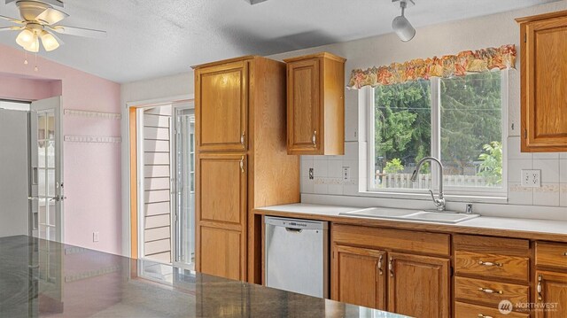 41427 Mountain View Pl E, Gold Bar, WA 98251 - kitchen with dishwasher, a ceiling fan, brown cabinets, decorative backsplash, and vaulted ceiling