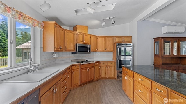 41427 Mountain View Pl E, Gold Bar, WA 98251 - kitchen with stainless steel appliances, a wall mounted AC, light wood-type flooring, decorative backsplash, and a skylight