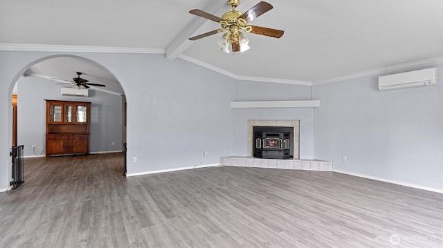 41427 Mountain View Pl E, Gold Bar, WA 98251 - unfurnished living room featuring a ceiling fan, arched walkways, a wall mounted air conditioner, wood finished floors, and ornamental molding