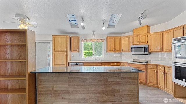 41427 Mountain View Pl E, Gold Bar, WA 98251 - kitchen featuring stainless steel appliances, rail lighting, decorative backsplash, a center island, and a textured ceiling