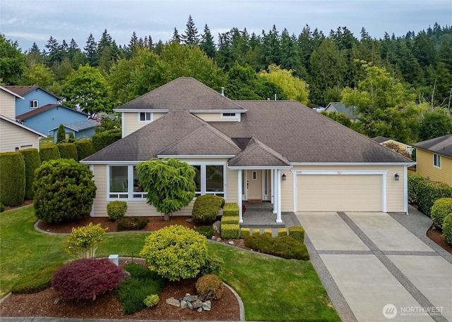 2108 S 18th St, Mount Vernon, WA 98274 - view of front facade featuring a garage, driveway, roof with shingles, a front yard, and a forest view