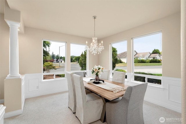 2108 S 18th St, Mount Vernon, WA 98274 - dining area featuring decorative columns, light carpet, a chandelier, a wainscoted wall, and healthy amount of natural light