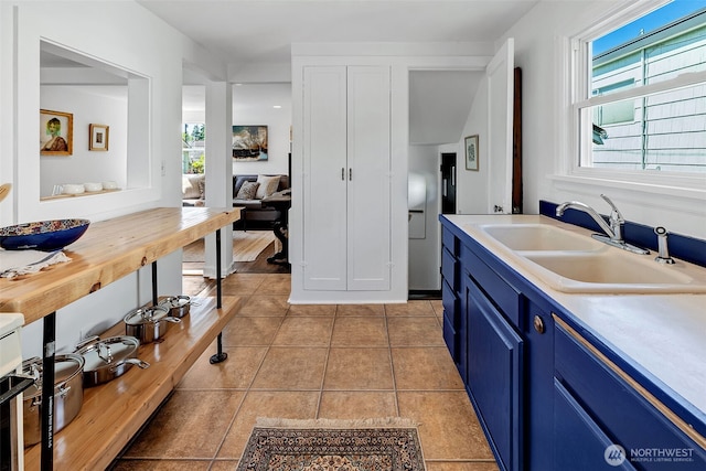 2711 NW 80th St, Seattle, WA 98117 - kitchen with blue cabinets, light countertops, and light tile patterned floors