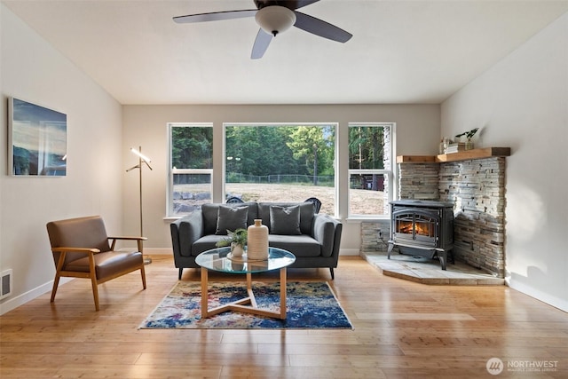 2733 Teal Lake Rd, Port Ludlow, WA 98365 - living room featuring a wood stove, healthy amount of natural light, hardwood / wood-style flooring, and a ceiling fan