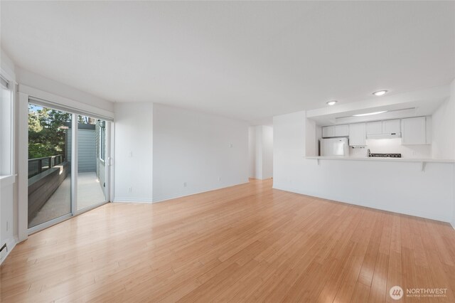 6055 35th Ave SW Unit 308, Seattle, WA 98126 - unfurnished living room featuring light wood-type flooring and recessed lighting