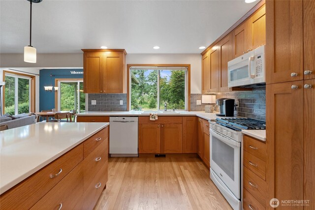 5207 170th St E, Tacoma, WA 98446 - kitchen featuring white appliances, light countertops, decorative backsplash, plenty of natural light, and recessed lighting