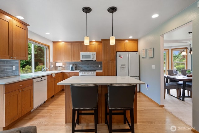 5207 170th St E, Tacoma, WA 98446 - kitchen with white appliances, light countertops, decorative backsplash, a kitchen island, and recessed lighting