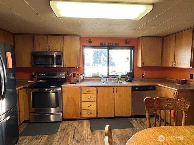 79 Duck Lake Rd, Omak, WA 98841 - kitchen featuring stainless steel appliances, wood finished floors, light countertops, and brown cabinets