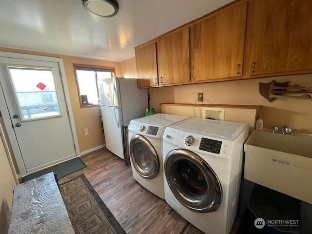 79 Duck Lake Rd, Omak, WA 98841 - washroom with separate washer and dryer, light wood-style flooring, and cabinet space