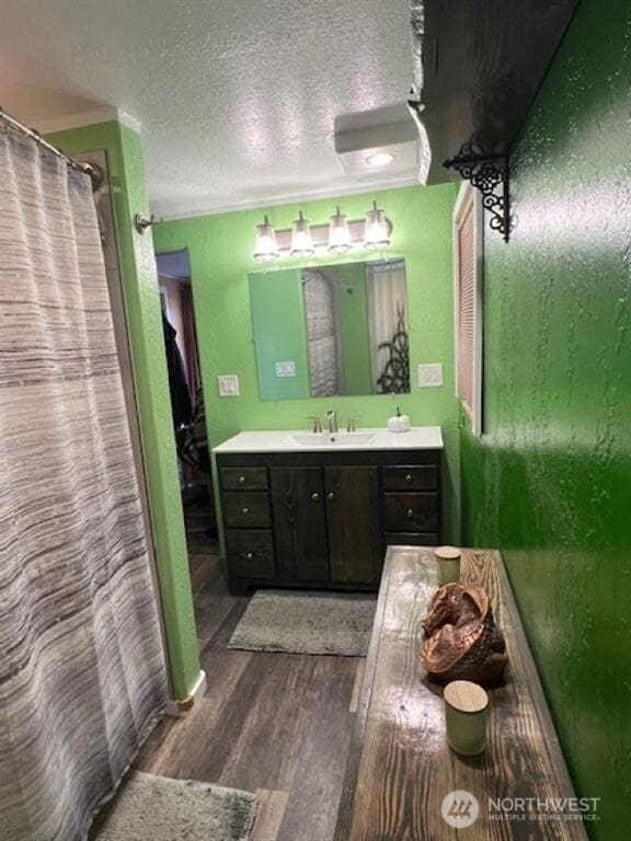 79 Duck Lake Rd, Omak, WA 98841 - full bathroom with vanity, wood finished floors, a textured ceiling, and a shower with shower curtain