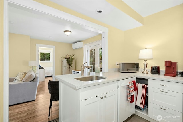 9359 SW 31st Pl, Seattle, WA 98126 - kitchen with dishwasher, stainless steel microwave, a peninsula, white cabinetry, and a kitchen bar