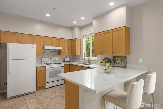 16107 NE 90th Way Unit 3304, Redmond, WA 98052 - kitchen with white appliances, under cabinet range hood, a peninsula, light tile patterned flooring, and a breakfast bar area