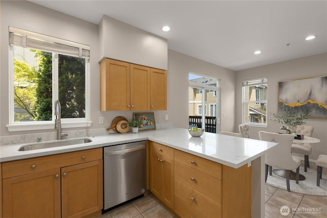 16107 NE 90th Way Unit 3304, Redmond, WA 98052 - kitchen with stainless steel dishwasher, light tile patterned flooring, light countertops, a peninsula, and healthy amount of natural light