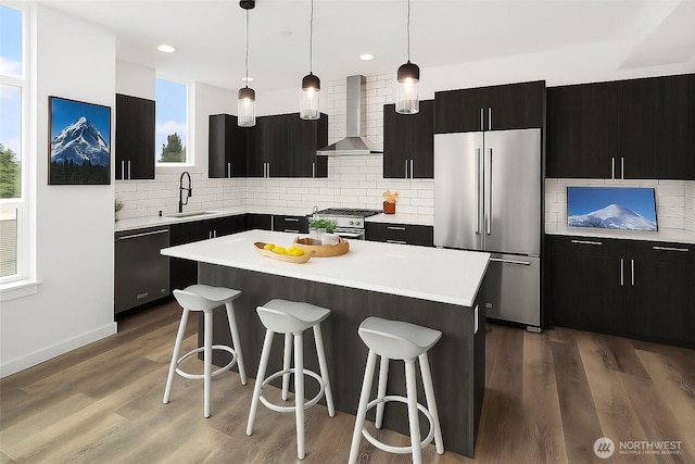 16547 NE 92nd Pl Unit 6A, Redmond, WA 98052 - kitchen with stainless steel appliances, wall chimney exhaust hood, a breakfast bar area, dark cabinetry, and recessed lighting
