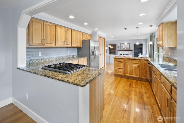 21227 SE 29th St, Sammamish, WA 98075 - kitchen with appliances with stainless steel finishes, a peninsula, light stone counters, tasteful backsplash, and light wood-style floors