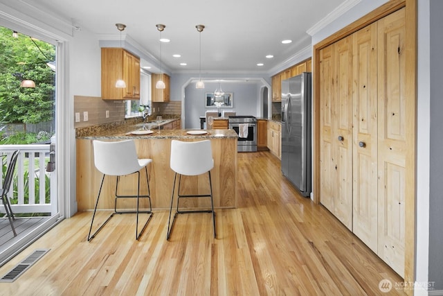 21227 SE 29th St, Sammamish, WA 98075 - kitchen featuring appliances with stainless steel finishes, a peninsula, light wood finished floors, decorative backsplash, and recessed lighting