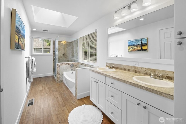 21227 SE 29th St, Sammamish, WA 98075 - bathroom featuring a skylight, a stall shower, double vanity, a garden tub, and wood finished floors