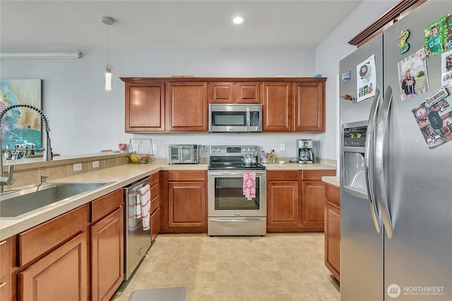 4023 Tribute Ave E, Fife, WA 98424 - kitchen featuring appliances with stainless steel finishes, brown cabinetry, pendant lighting, light countertops, and recessed lighting