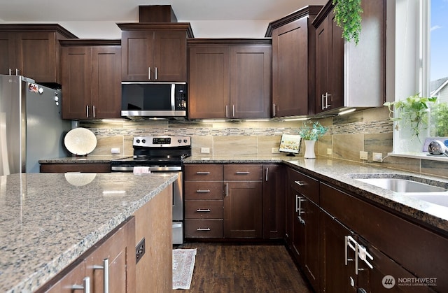 14410 99th Way SE, Yelm, WA 98597 - kitchen featuring stainless steel appliances, light stone counters, dark wood-style floors, decorative backsplash, and dark brown cabinets
