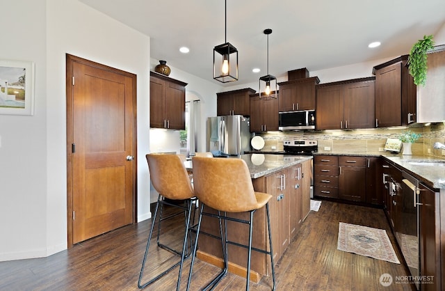 14410 99th Way SE, Yelm, WA 98597 - kitchen featuring appliances with stainless steel finishes, a center island, backsplash, dark wood-style flooring, and recessed lighting