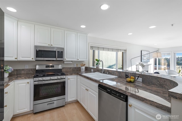 2241 13th Ave W, Seattle, WA 98119 - kitchen with appliances with stainless steel finishes, white cabinetry, light wood finished floors, recessed lighting, and tile countertops