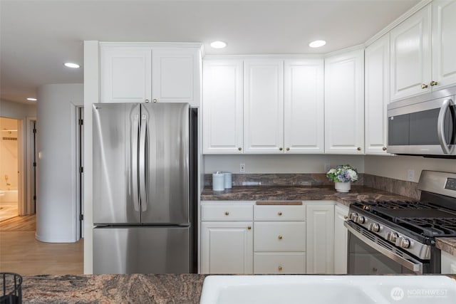 2241 13th Ave W, Seattle, WA 98119 - kitchen with stainless steel appliances, white cabinetry, recessed lighting, and wood finished floors