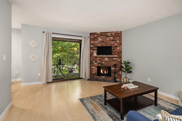 12023 100th Ave NE Unit C4, Kirkland, WA 98034 - living room featuring wood finished floors, a brick fireplace, and a textured ceiling