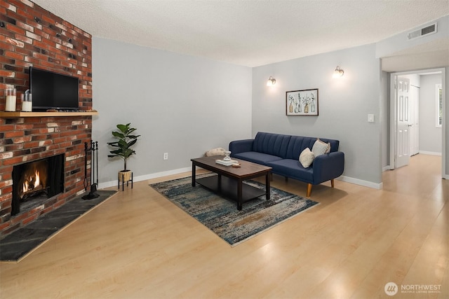 12023 100th Ave NE Unit C4, Kirkland, WA 98034 - living room with wood finished floors, a brick fireplace, and a textured ceiling
