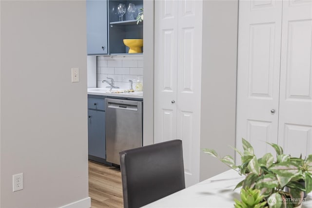 8845 166th Ave NE Unit B101, Redmond, WA 98052 - kitchen featuring stainless steel dishwasher, blue cabinets, light countertops, tasteful backsplash, and light wood-type flooring