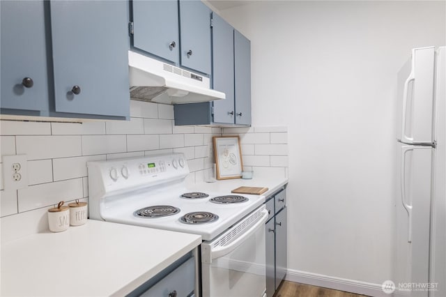 8845 166th Ave NE Unit B101, Redmond, WA 98052 - kitchen featuring white appliances, under cabinet range hood, blue cabinetry, and decorative backsplash