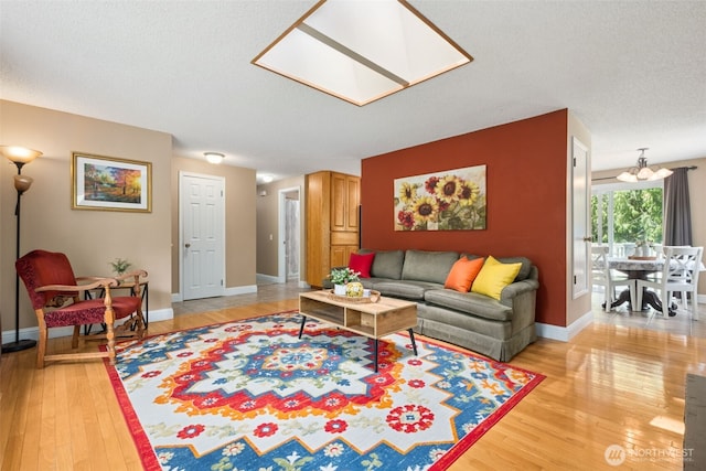 14531 262nd Ave SE, Issaquah, WA 98027 - living area featuring light wood-style floors, a skylight, a chandelier, and a textured ceiling