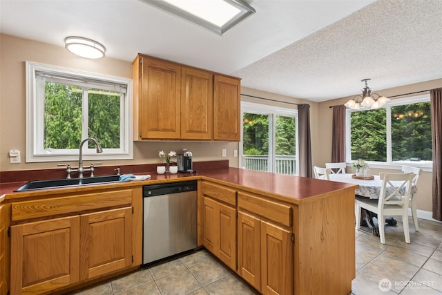 14531 262nd Ave SE, Issaquah, WA 98027 - kitchen featuring stainless steel dishwasher, a peninsula, light tile patterned floors, a chandelier, and dark countertops