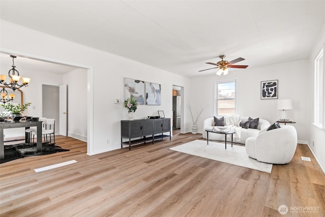 6719 46th Ave S, Seattle, WA 98118 - living room with light wood finished floors, a chandelier, and a ceiling fan